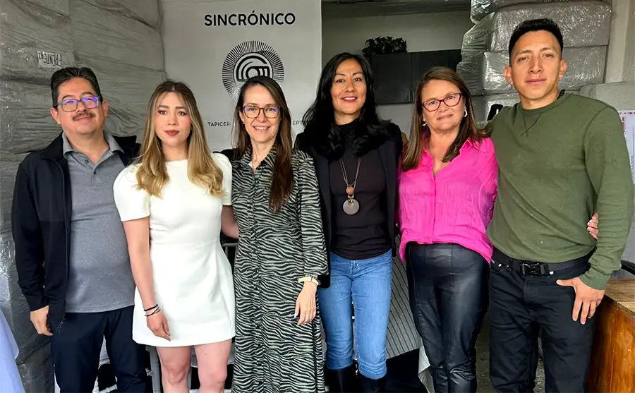 Mujeres emprendedoras operando maquinaria textil industrial