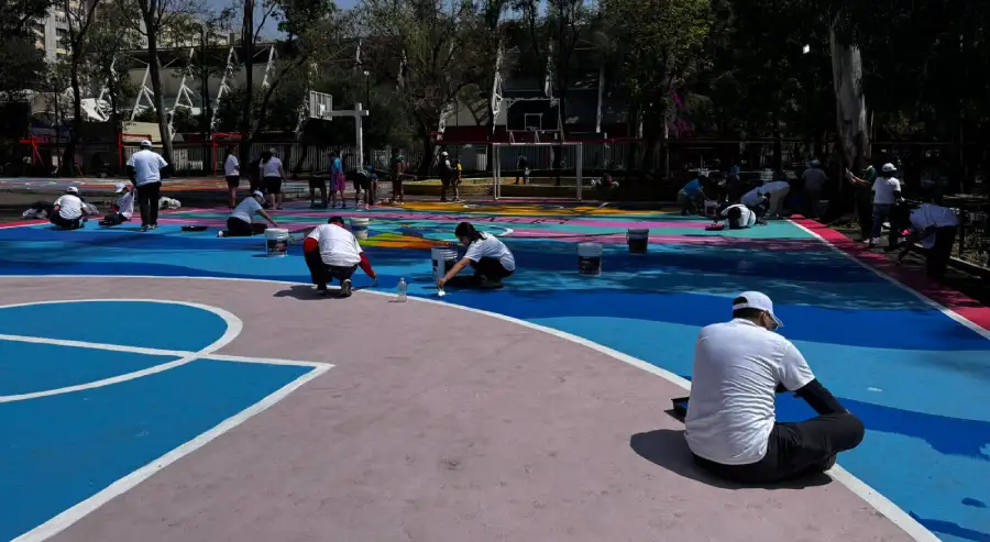 Voluntarios rehabilitando cancha deportiva comunitaria